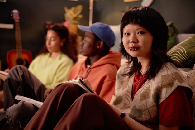 A visually appealing image of a group of diverse people watching a Korean drama on a big screen at a viewing party. The group is shown laughing and reacting emotionally to the scenes, emphasizing the communal and engaging experience of watching K-dramas. The snacks and decorations are K-drama themed.