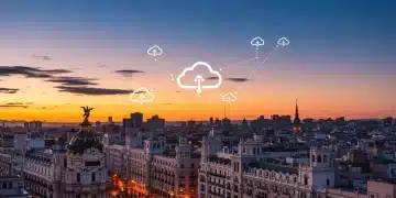Nube en España: Tendencias y Migraciones Estratégicas 2025 Paisaje urbano futurista de Madrid al atardecer con iconos de nube y flujos de datos digitales, simbolizando la computación en la nube en España.