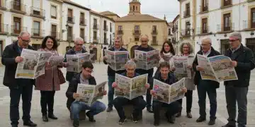 Vecinos de un pueblo español leyendo periódicos locales y conversando animadamente en una plaza, simbolizando la cohesión social.