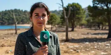 Periodista cubriendo un tema ambiental en un paisaje español afectado por el cambio climático