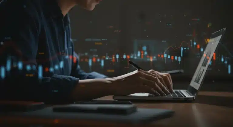 Periodista escribiendo en un ordenador portátil, rodeado de datos digitales, representando la protección de fuentes en el periodismo español.