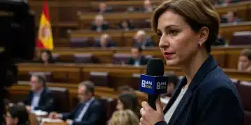 Regulación de Medios en España: 3 Normativas Clave para Periodistas 2025 Periodista con micrófono cubriendo sesión parlamentaria sobre regulación de medios en España.